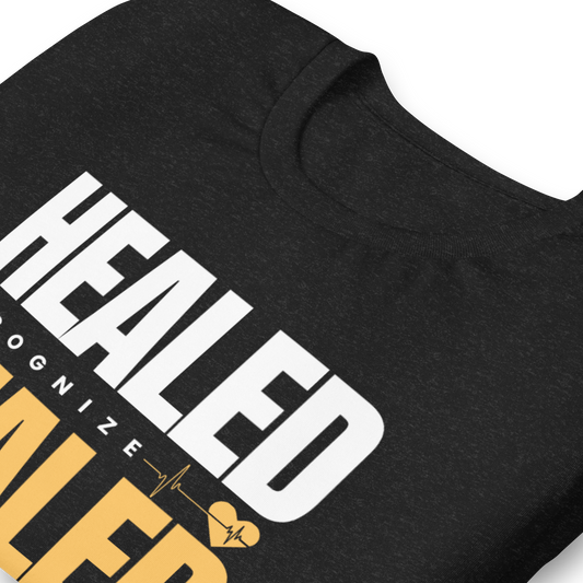 Black t-shirt with 'HEALD' printed in white and yellow text on a white background
