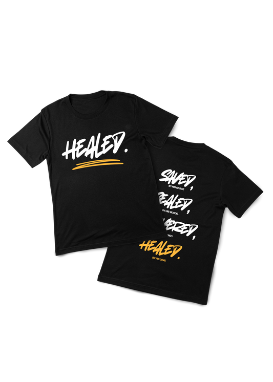 Two black t-shirts with 'HEALED' text on a white background